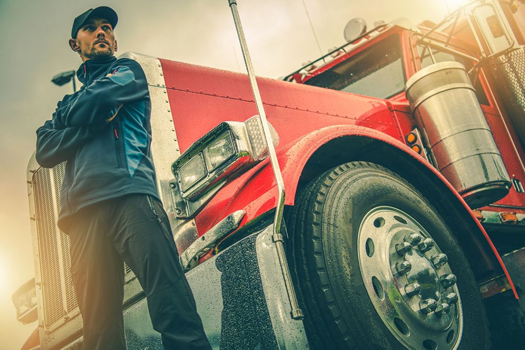 Driver standing in front of his semi.