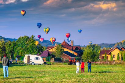 An RV near a hot air baloon festival.