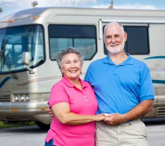 Couple standing in front of their RV